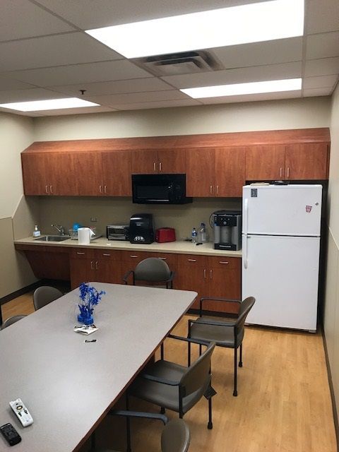 A kitchen with a table and chairs and a refrigerator