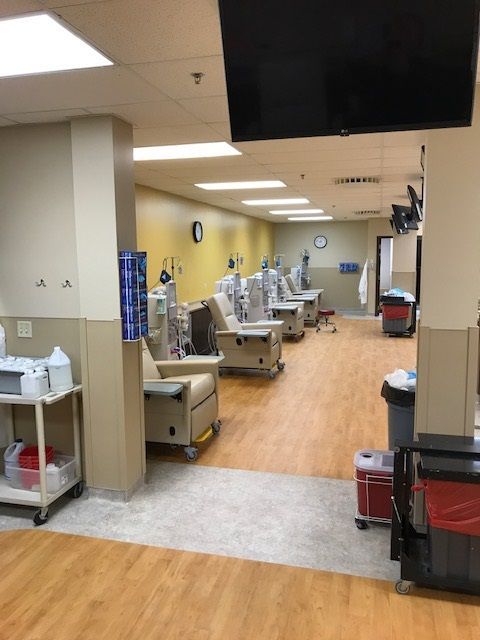 A hospital room with a lot of chairs and a tv