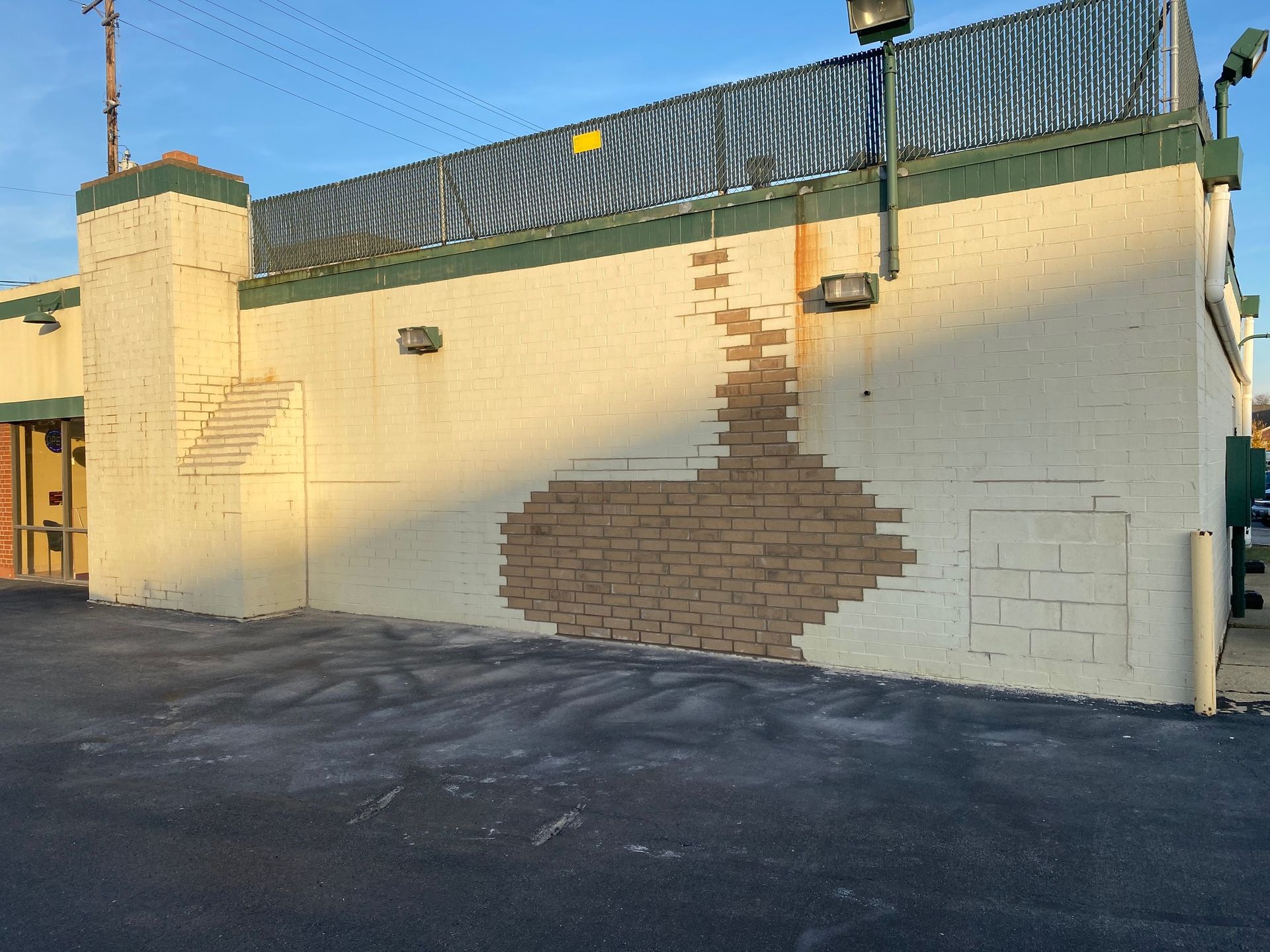A white building with a brick wall missing