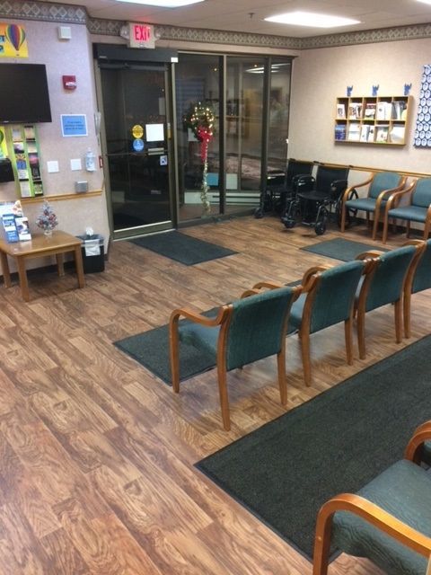 A waiting room with chairs and a tv on the wall