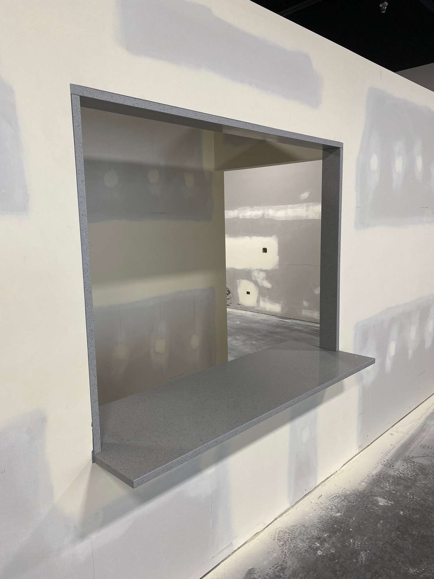 A white wall with a large window in it