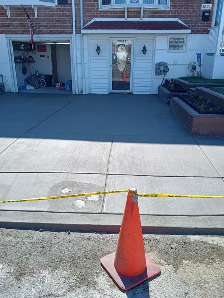 Orange traffic cone blocking a sidewalk in front of a brick townhouse entrance