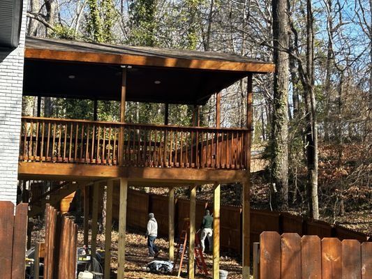 A large wooden deck is being built in the middle of a forest.