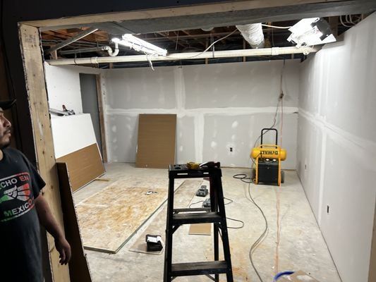 A man is standing in a room with a ladder in it.