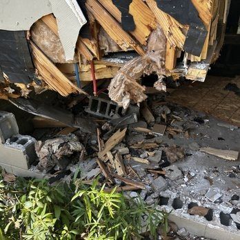 A rv has crashed into a concrete wall and is sitting on the ground.