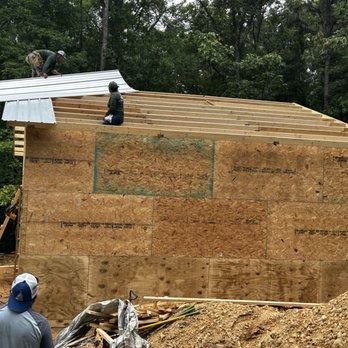 A group of men are working on the roof of a house.