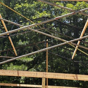 A metal structure with wooden beams and trees in the background