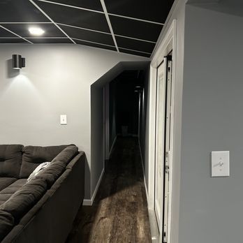 A living room with a couch and a long hallway.