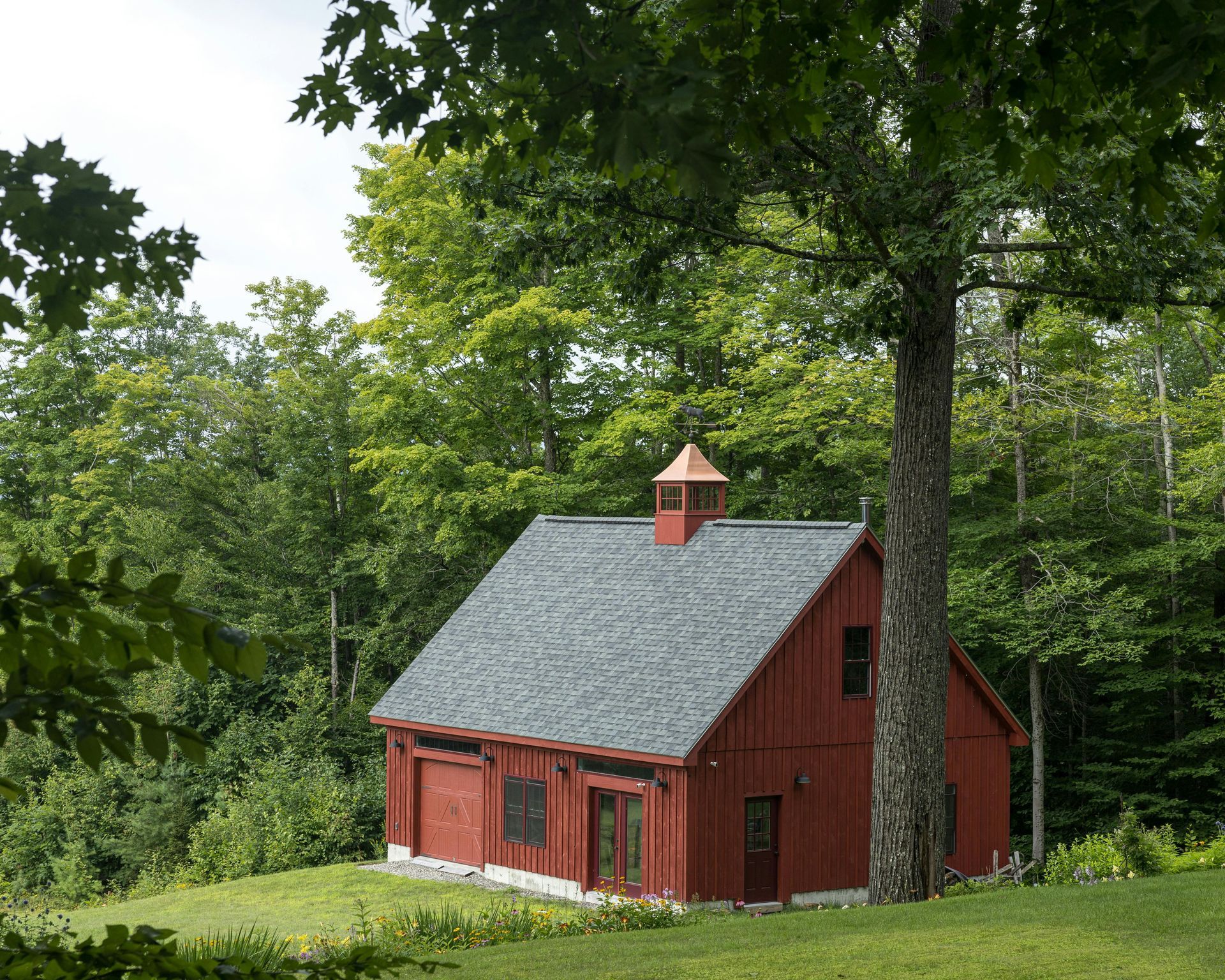A red barn with a tree in front of it