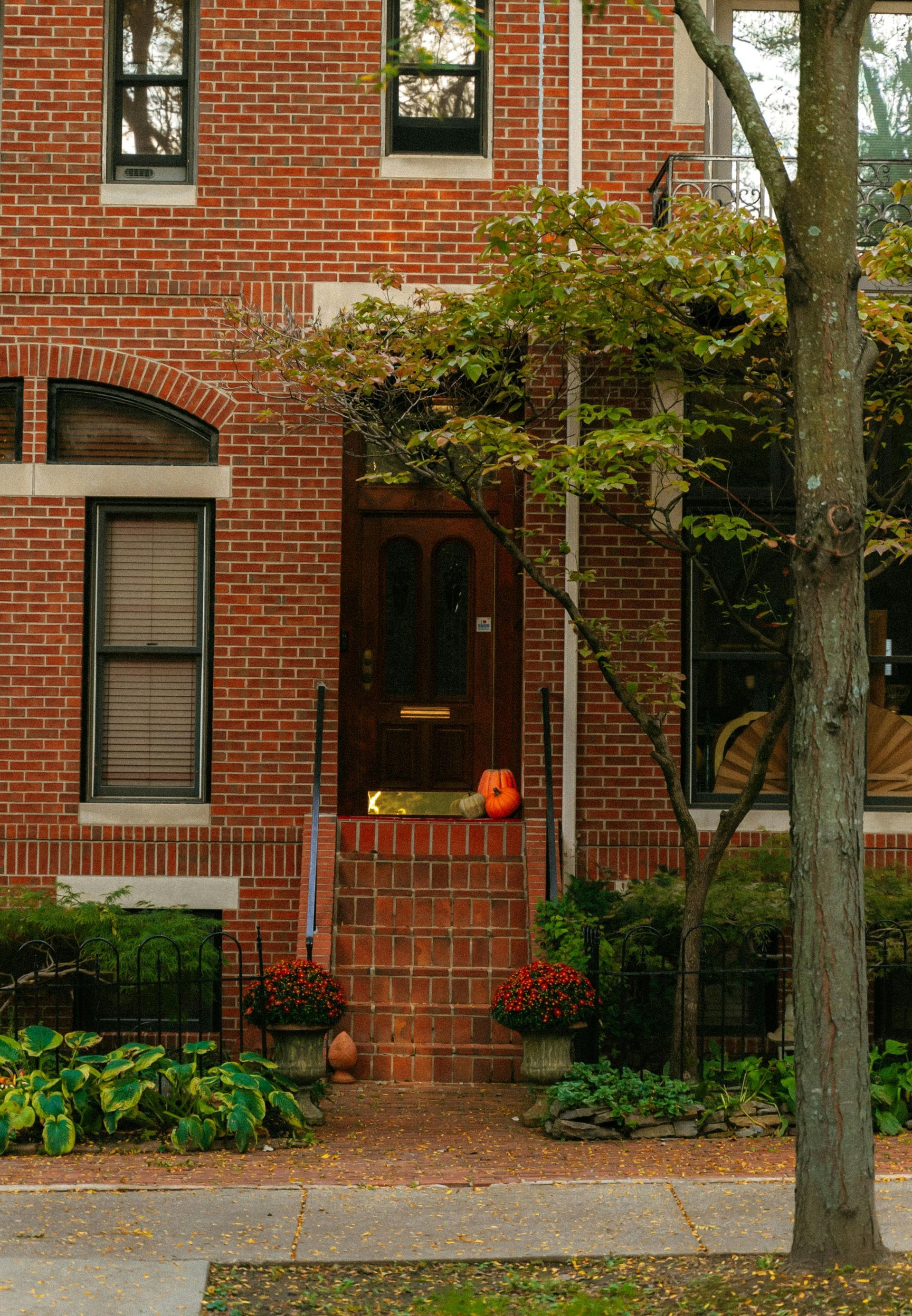 A brick house with a tree in front of it