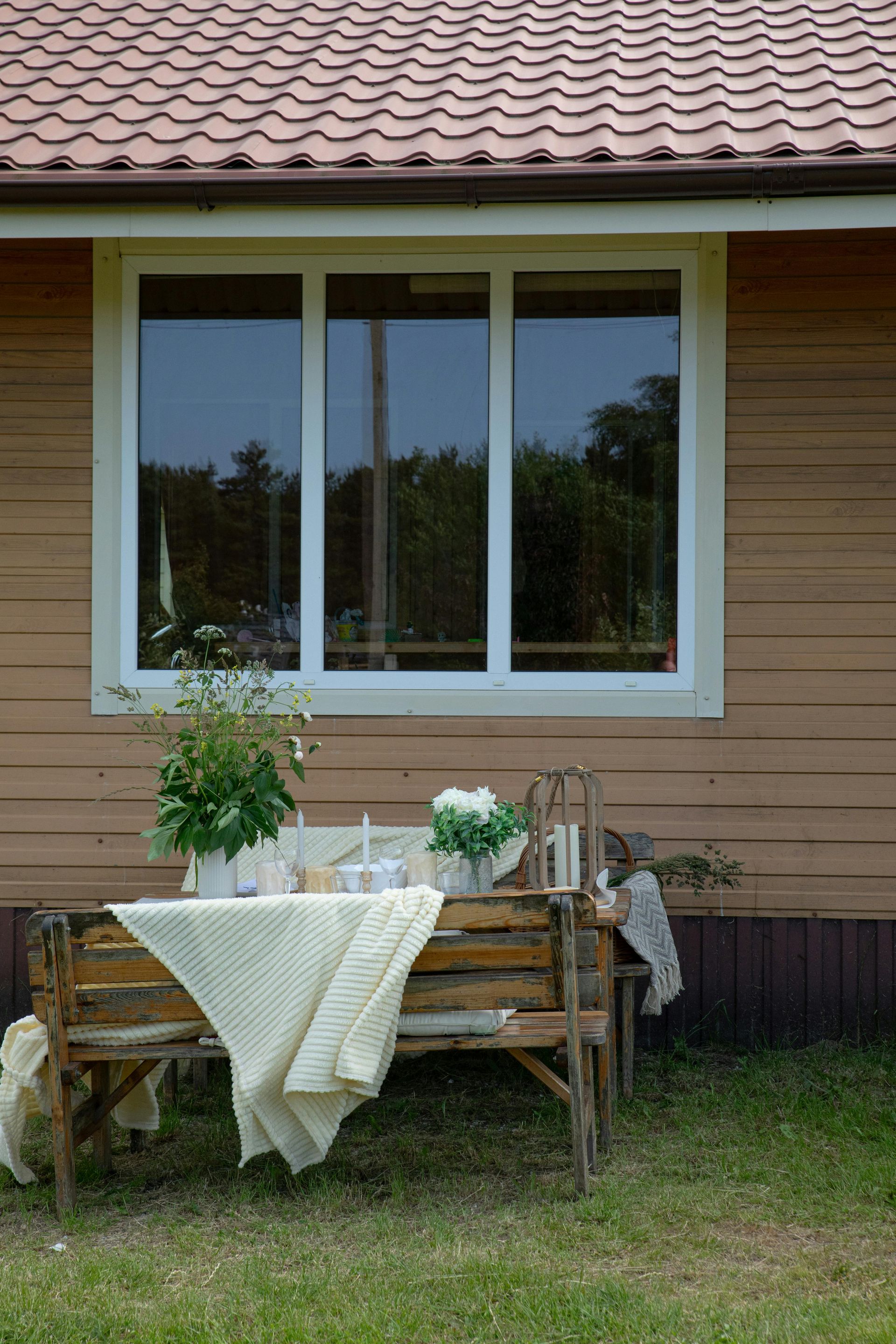 There is a table and bench in front of a house.