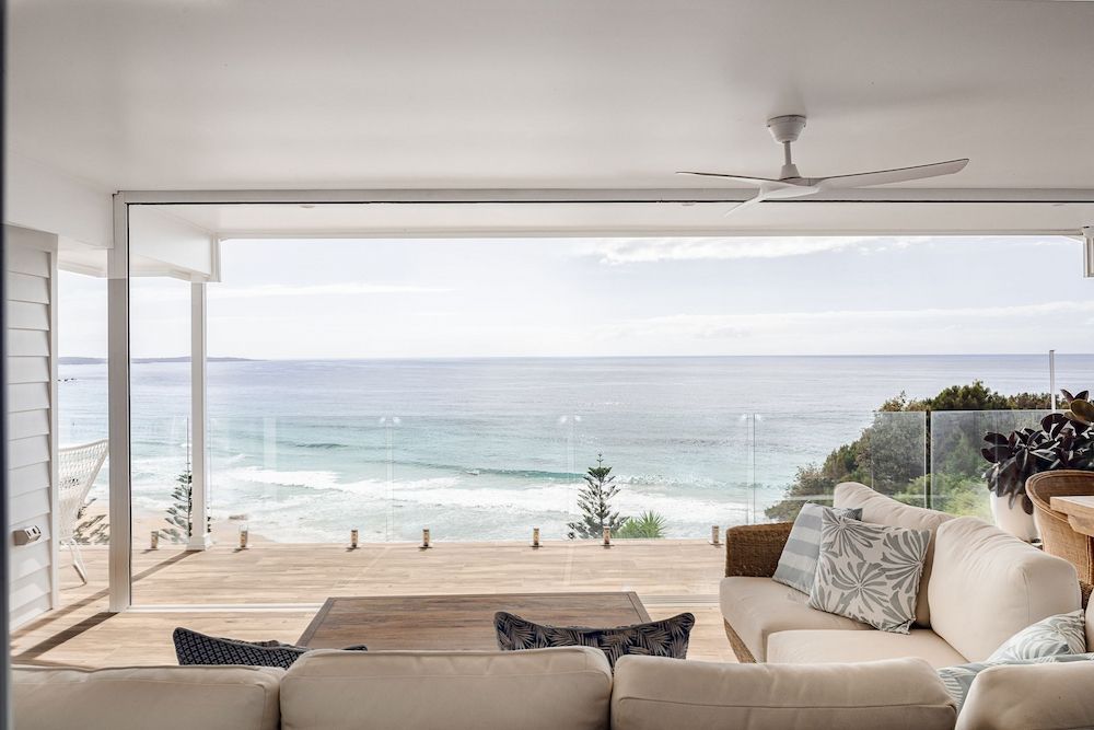 A Living Room With a Couch and a View of the Ocean — Mylec Electrical Solutions in Shell Cove, NSW