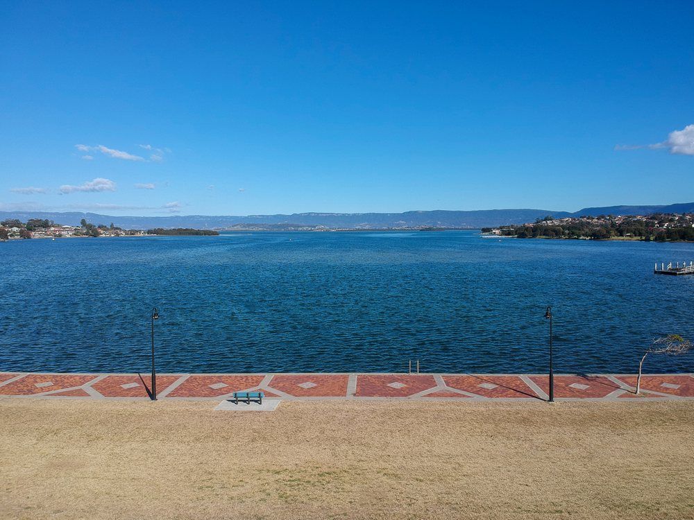 An Aerial View of a Large Body of Water With Mountains in the Background — Mylec Electrical Solutions in Illawarra, NSW