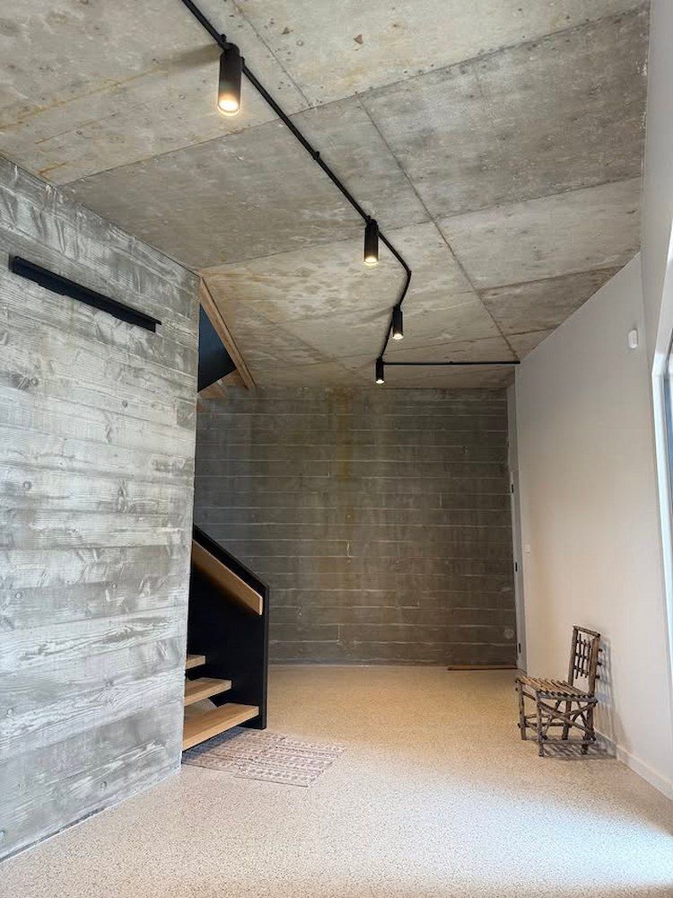 An Empty Room With a Staircase and a Chair in It — Mylec Electrical Solutions in North Wollongong, NSW