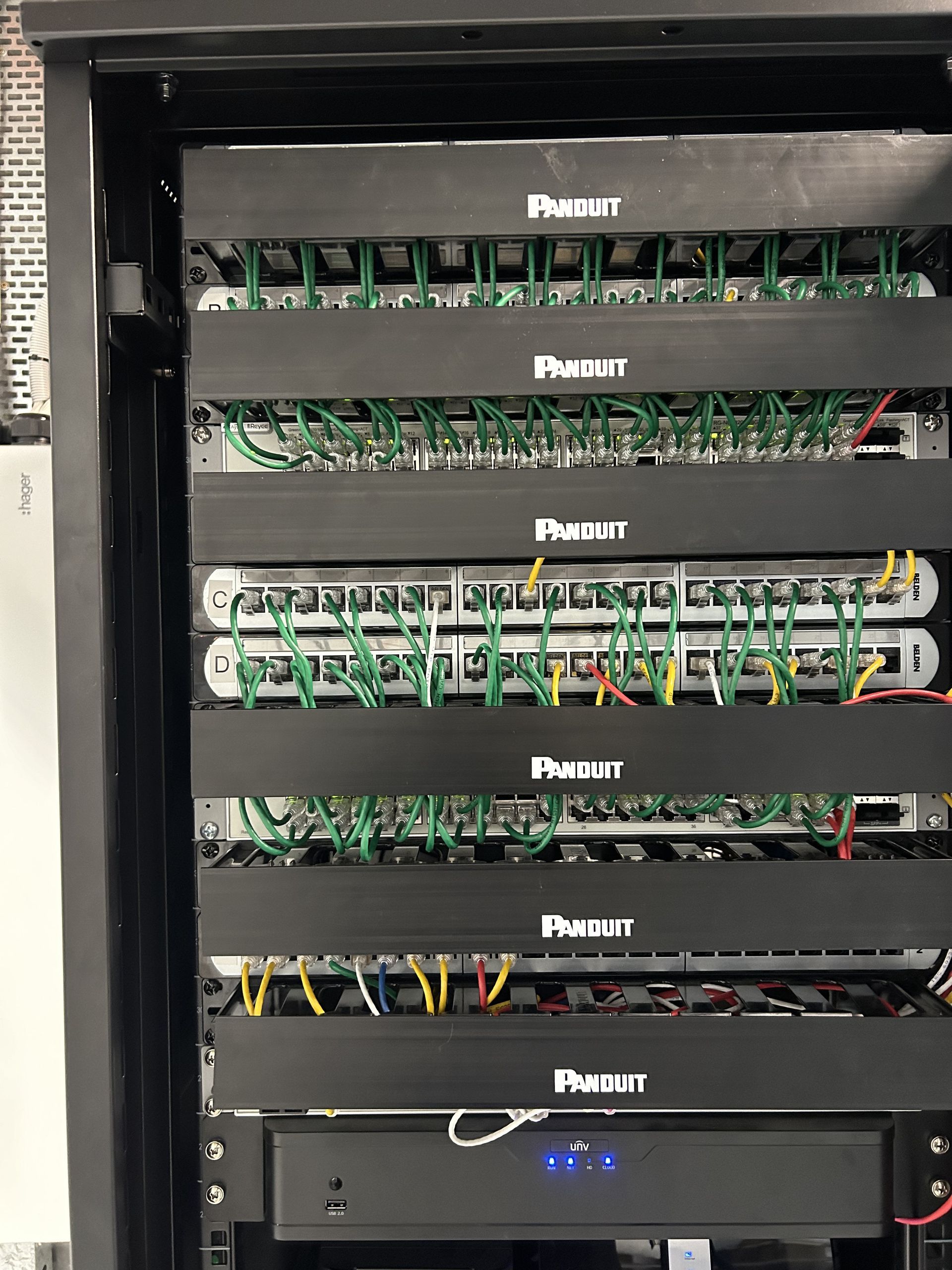 A server rack with a lot of wires coming out of it — Mylec Electrical Solutions in Shell Cove, NSW