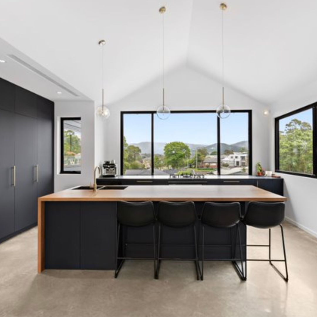 A Kitchen With a Large Island and Stools — Mylec Electrical Solutions in Shell Cove, NSW