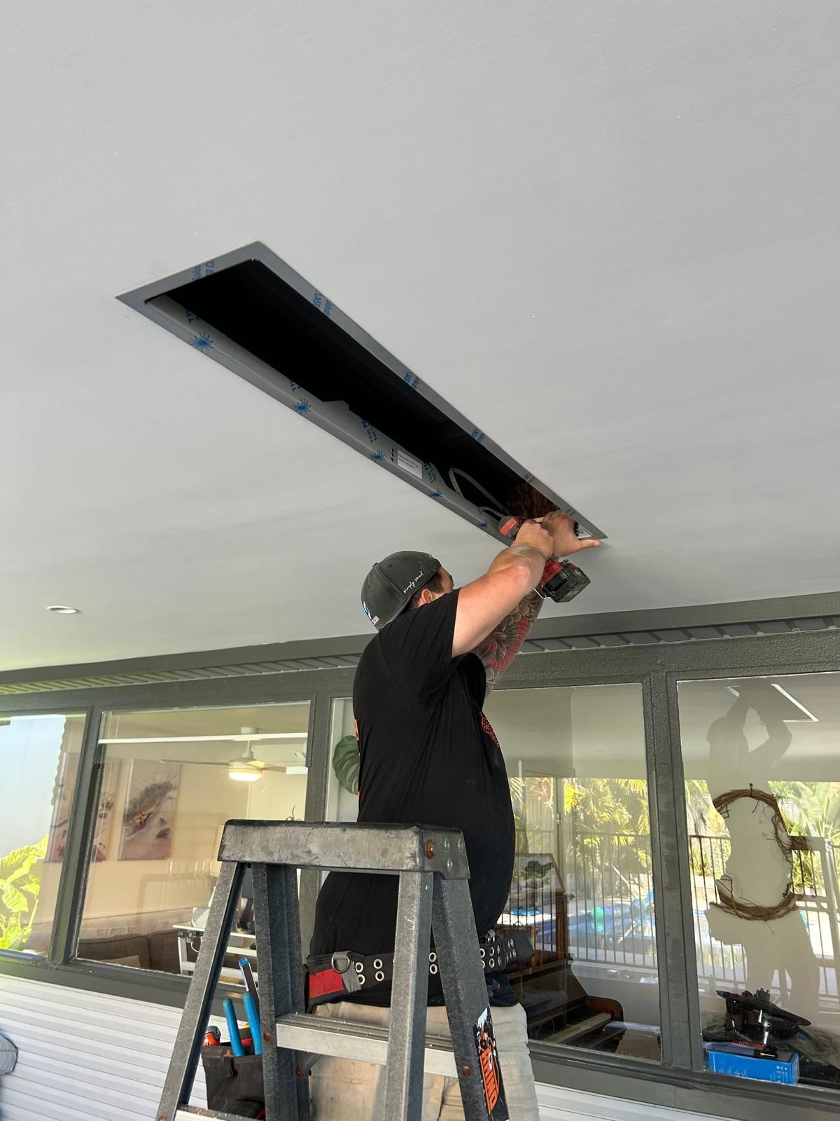 A White Living Room With A Wooden Table and White Chairs - Mylec Electrical Wollongong VIC
