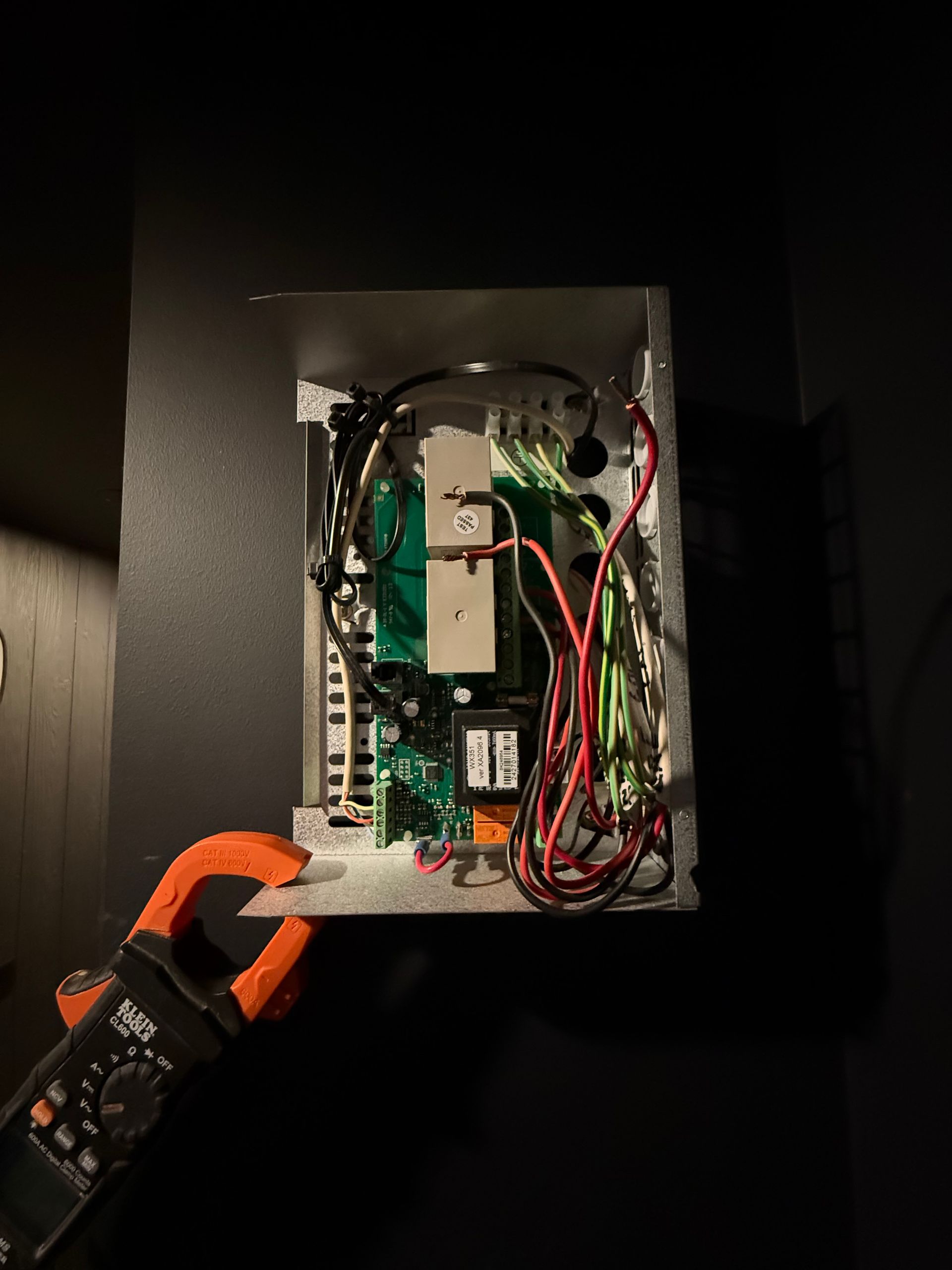 A clamp is holding a piece of electronic equipment in a box — Mylec Electrical Solutions in Shell Cove, NSW