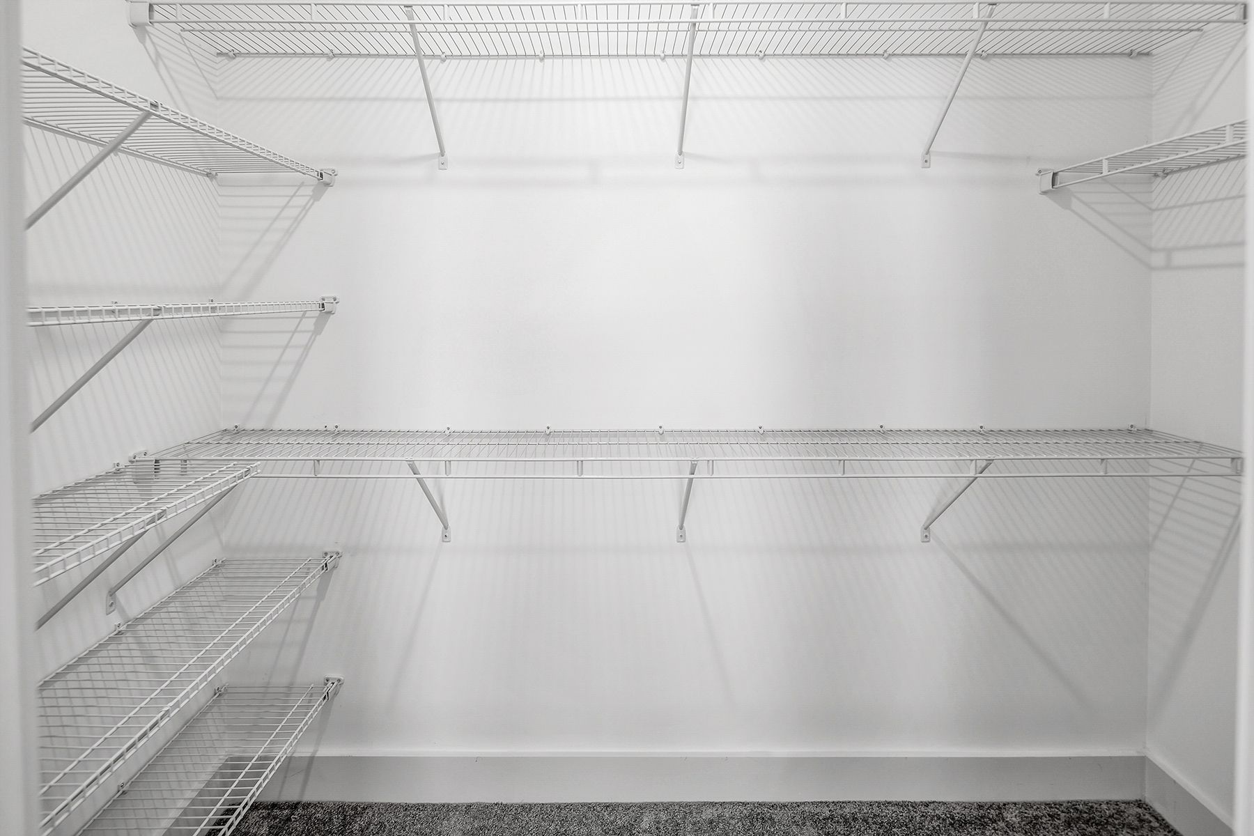 Empty white closet with wire shelving.