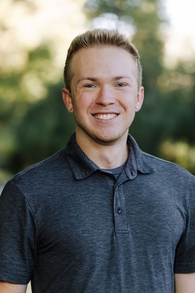 Agent Noble is smiling in front of a lake.