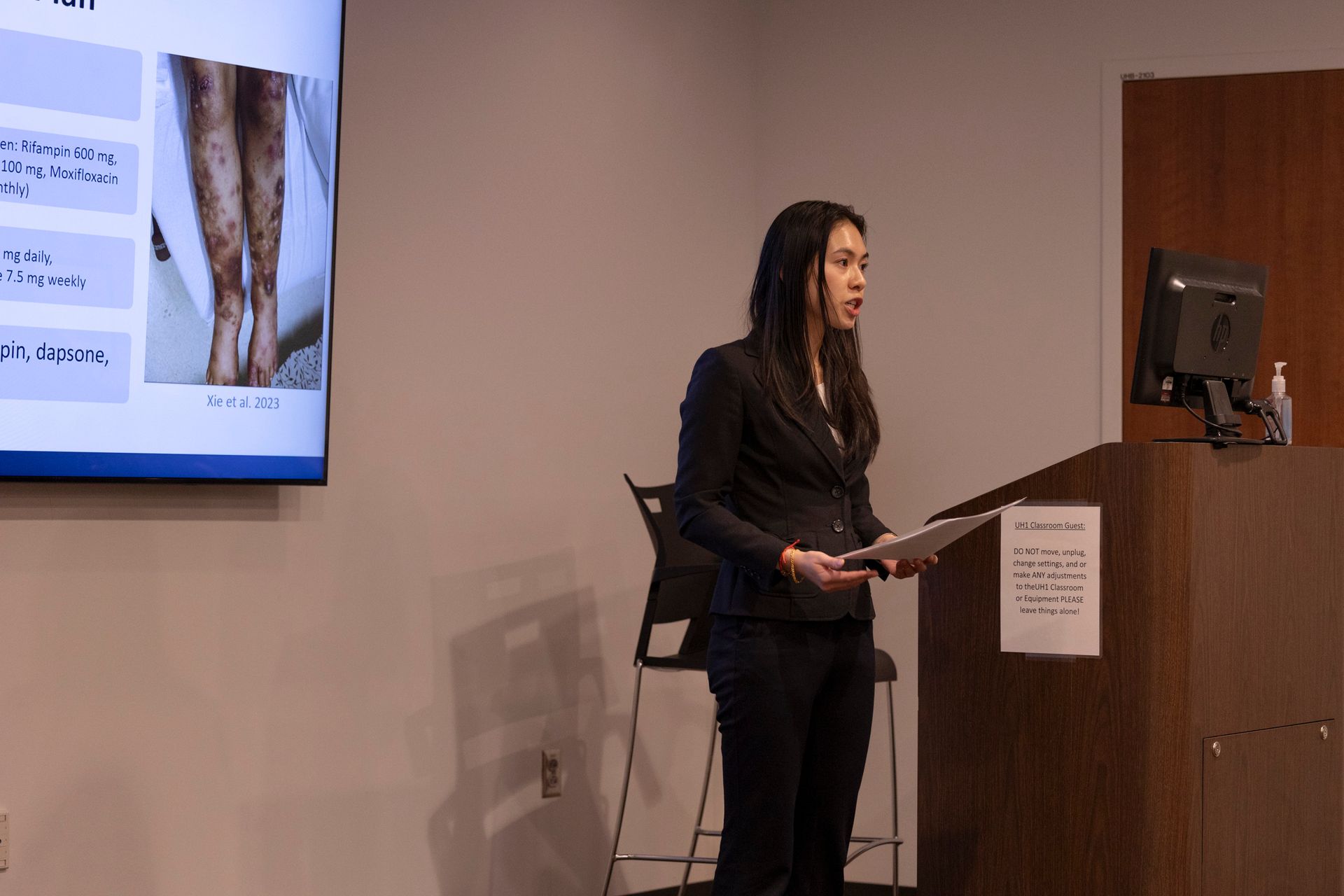 A woman is standing at a podium giving a presentation.