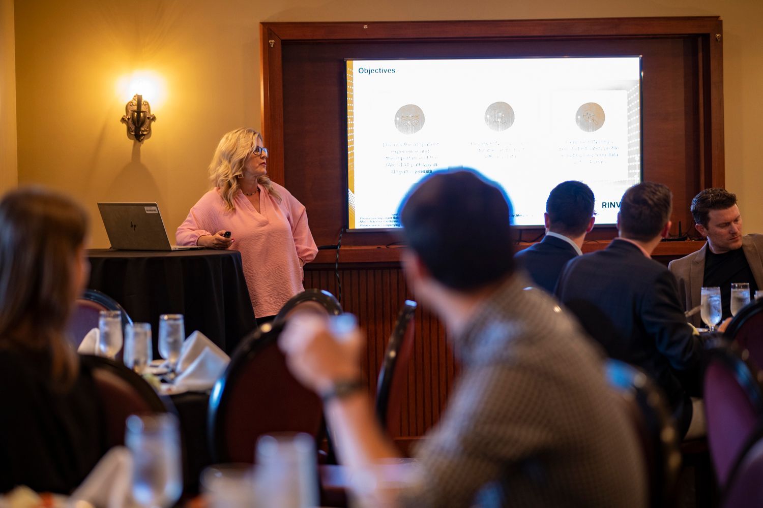 A woman is giving a presentation to a group of people at a conference.