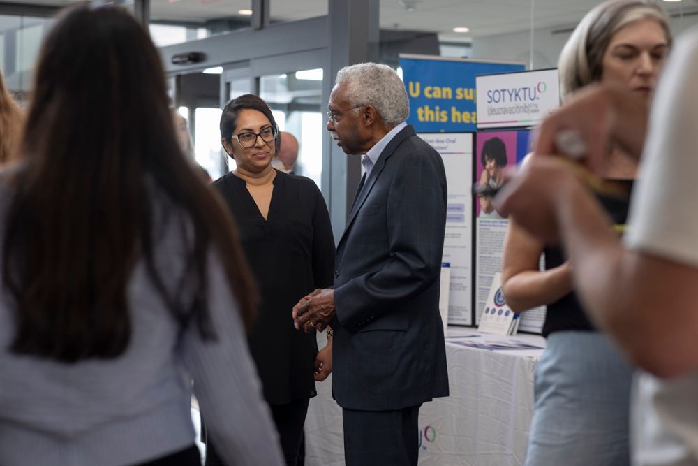 A man in a suit and tie is talking to a woman