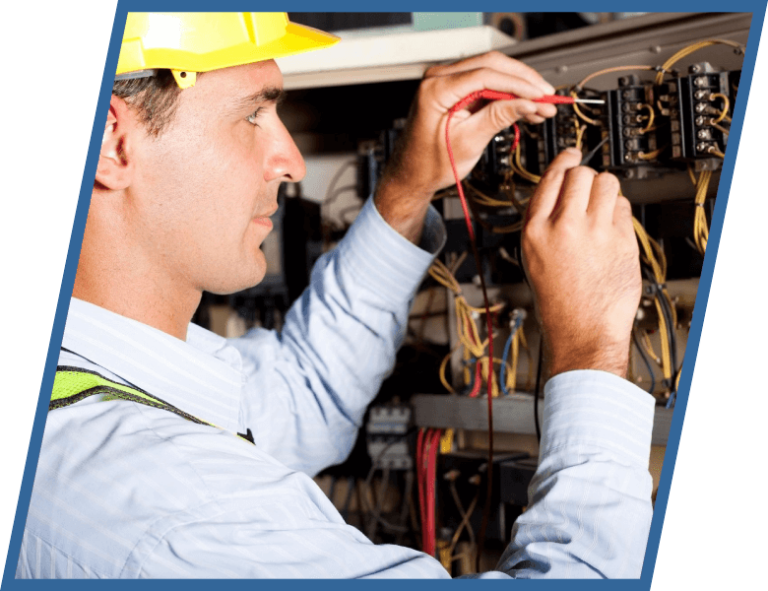 A man wearing a hard hat is working on electrical wires