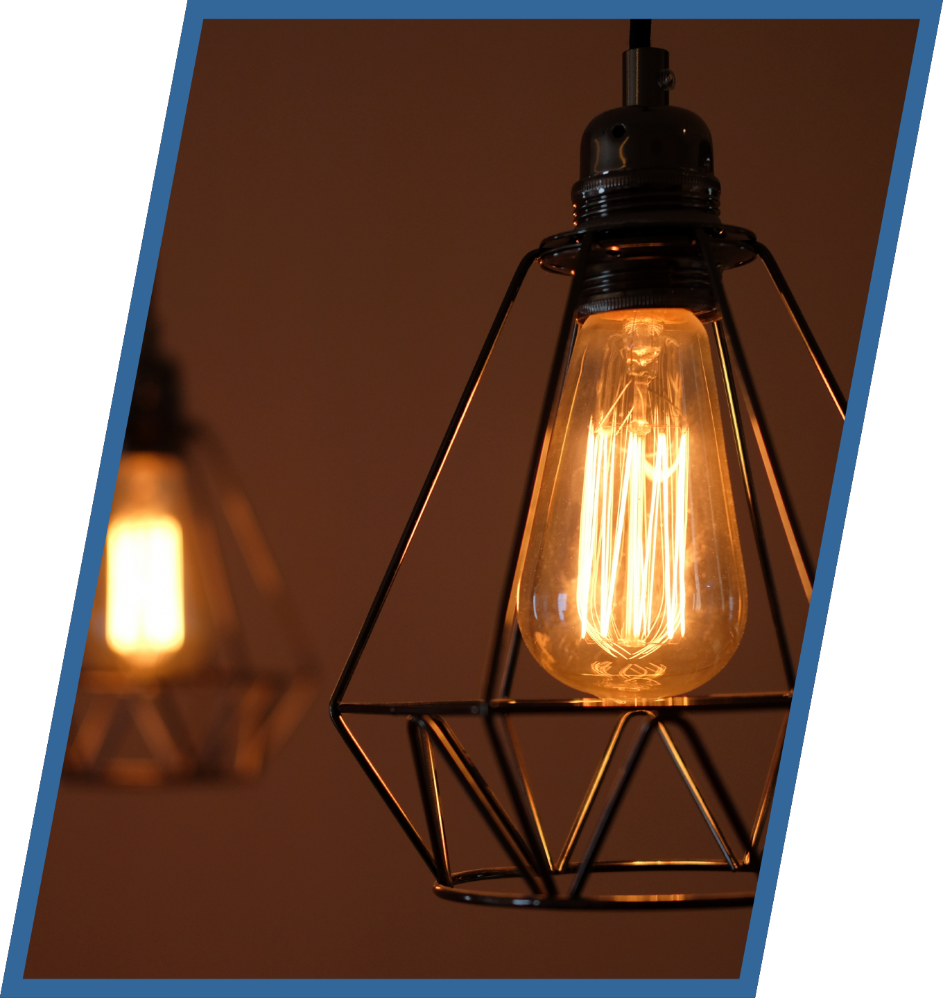 A light bulb hanging from a wire cage in a dark room