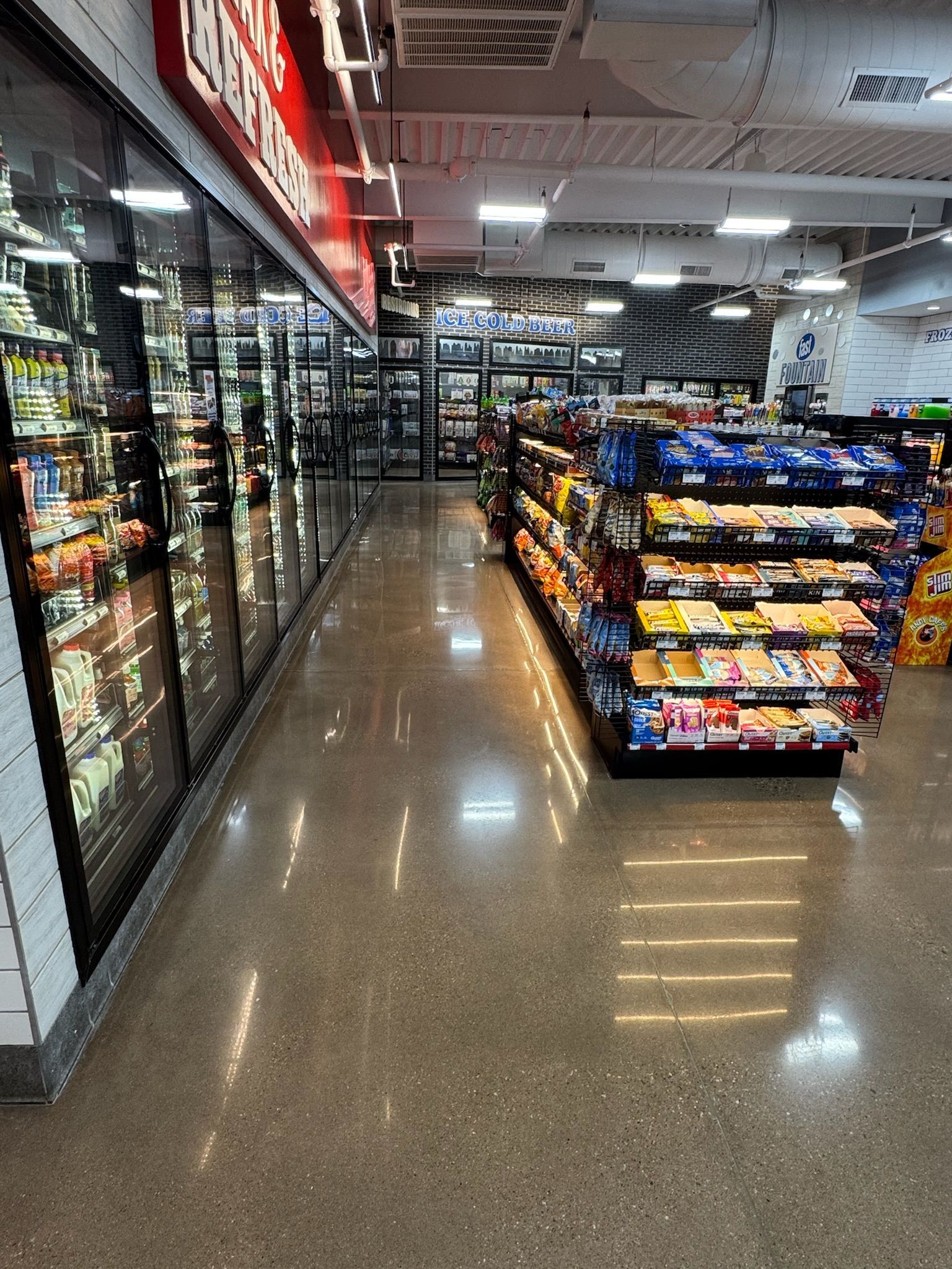 A shiny concrete floor in a store with a lot of shelves.