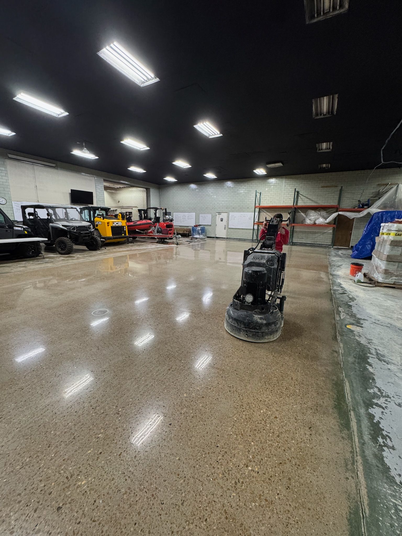 A close up of a garage floor with a shadow on the wall.