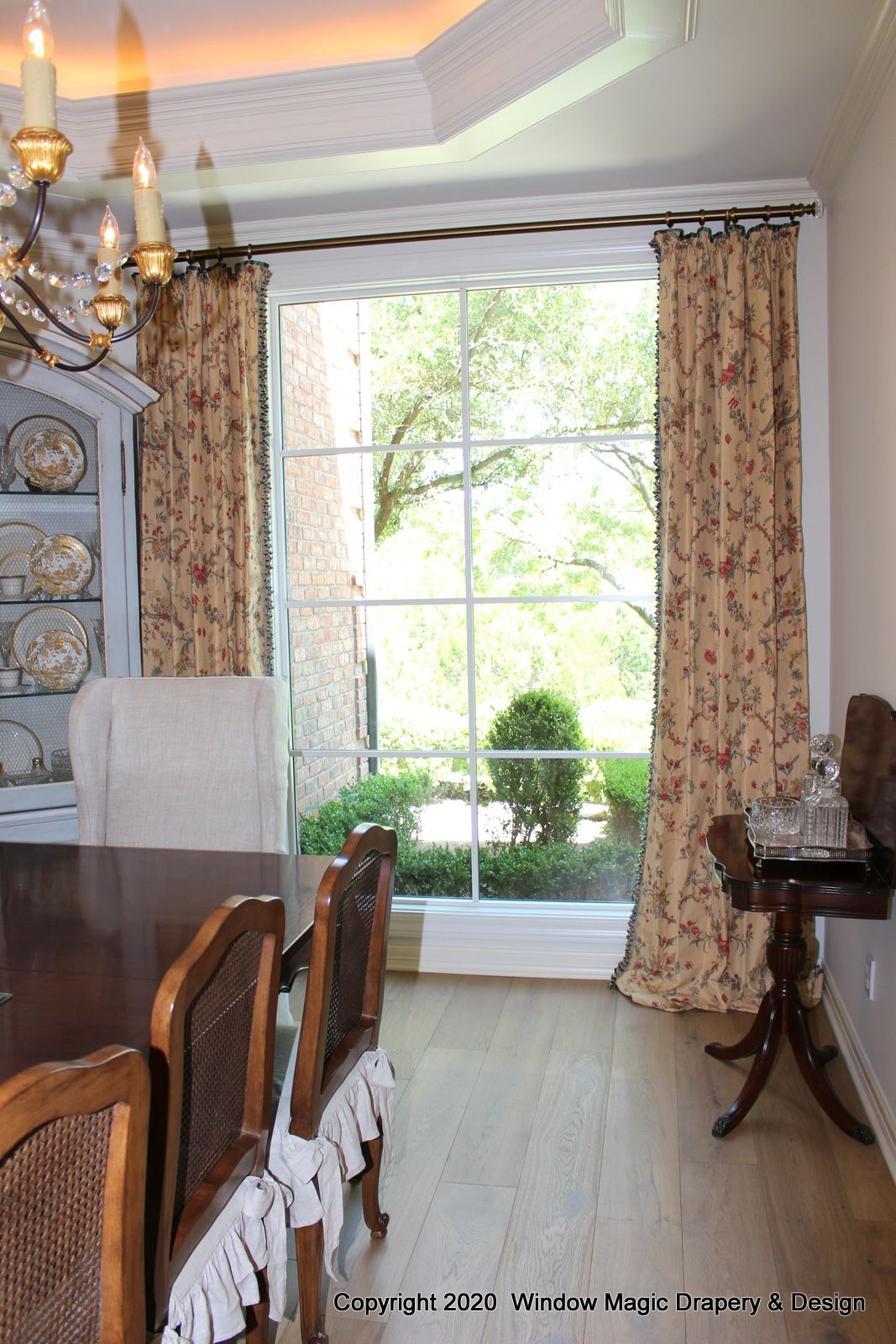 A dining room with a table and chairs and a large window.