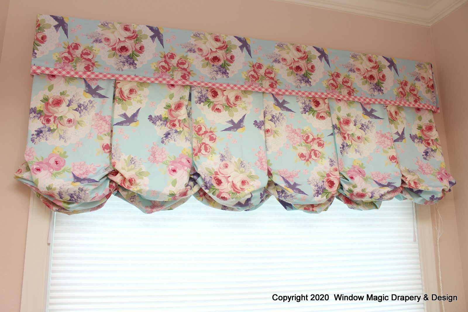 A window with a floral valance and birds on it.