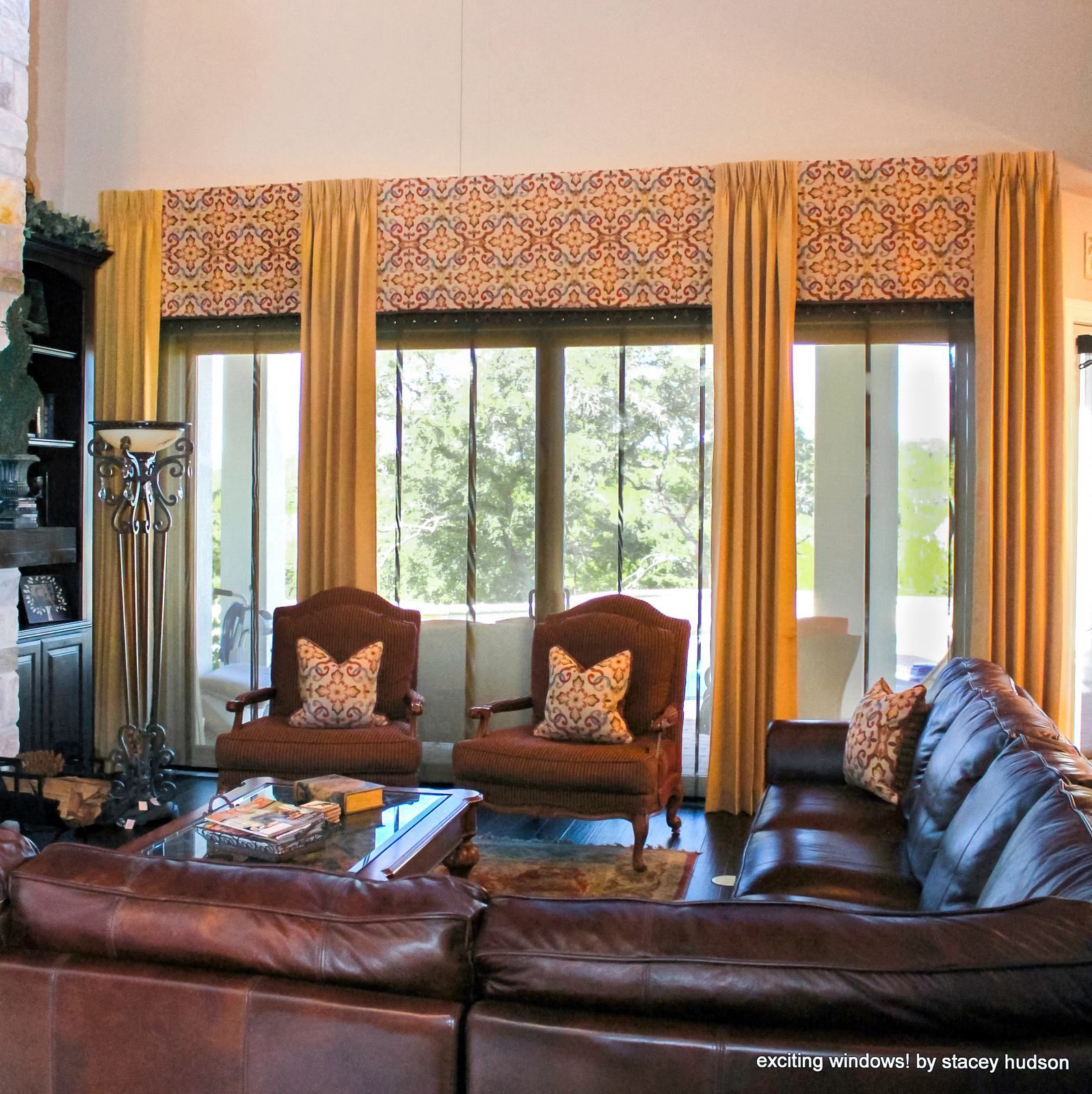 A living room with a brown leather couch and two chairs