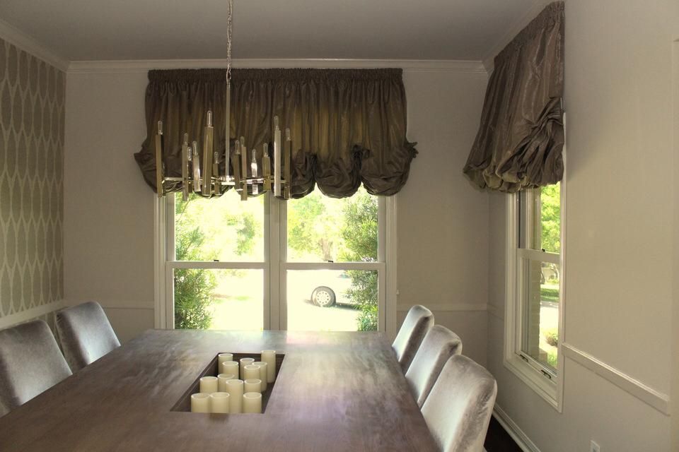 A dining room with a table and chairs and a chandelier