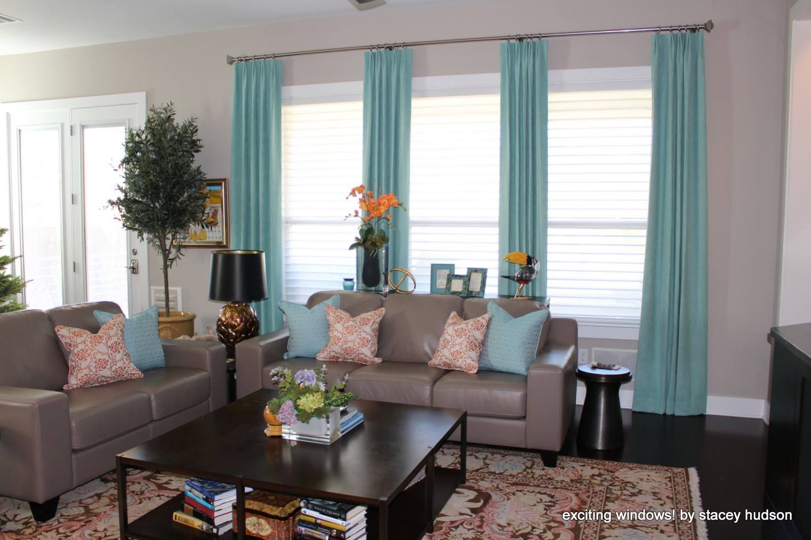 A living room with two couches , a coffee table , and blue curtains.