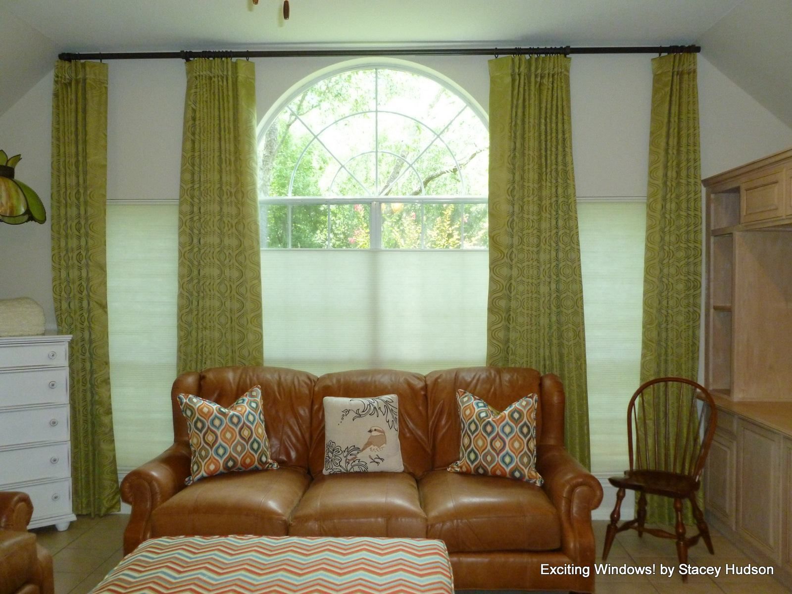A living room with a brown couch and green curtains