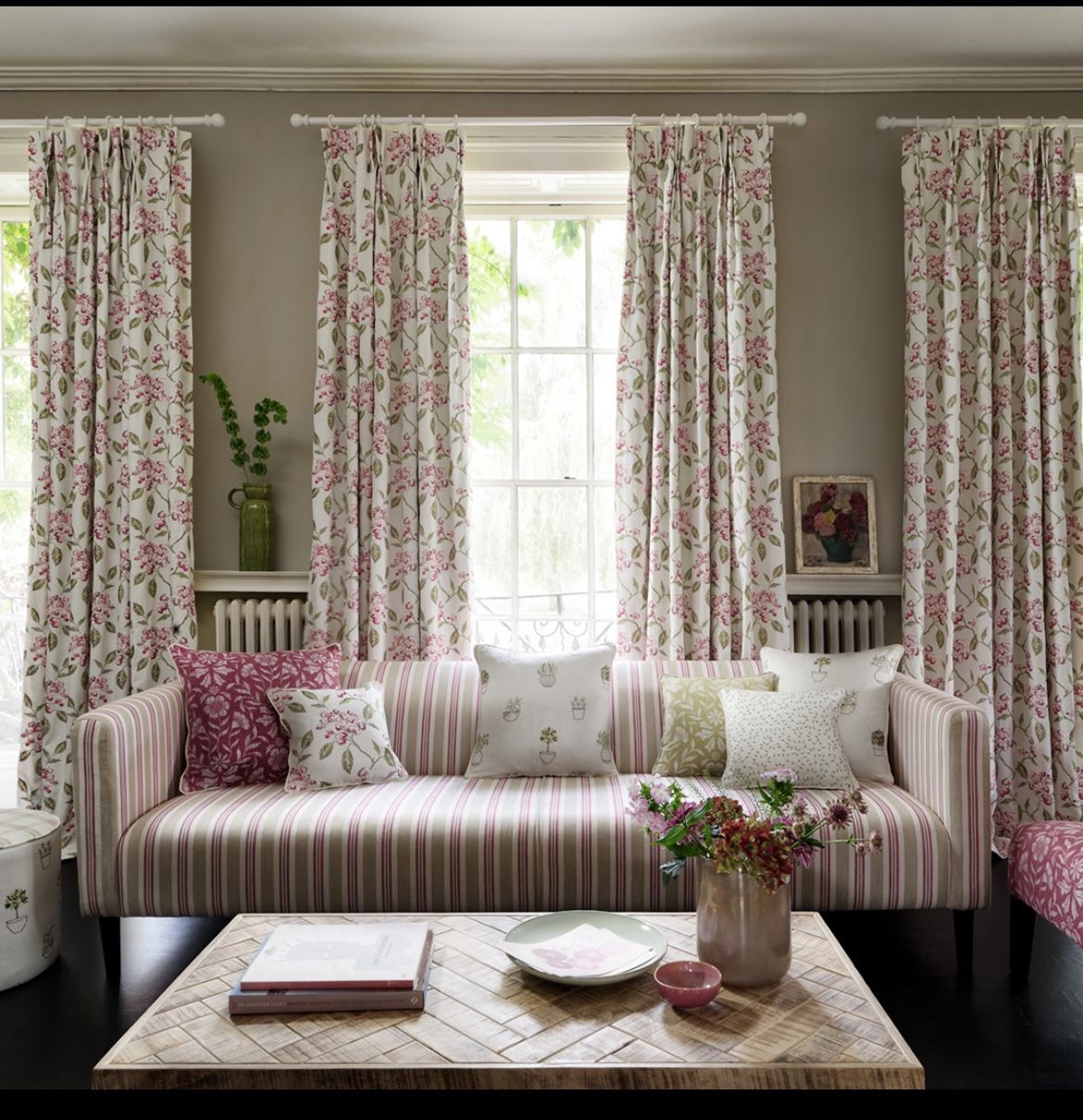 A living room with a striped couch and floral curtains