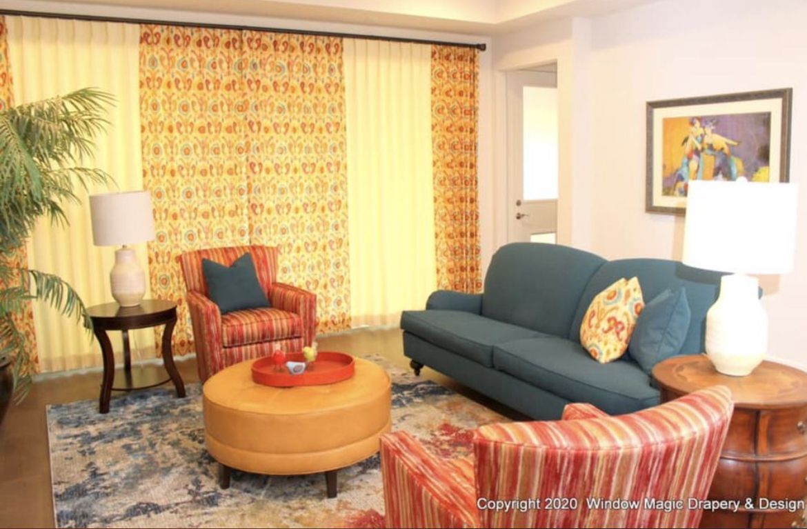 A living room with a blue couch and red chairs