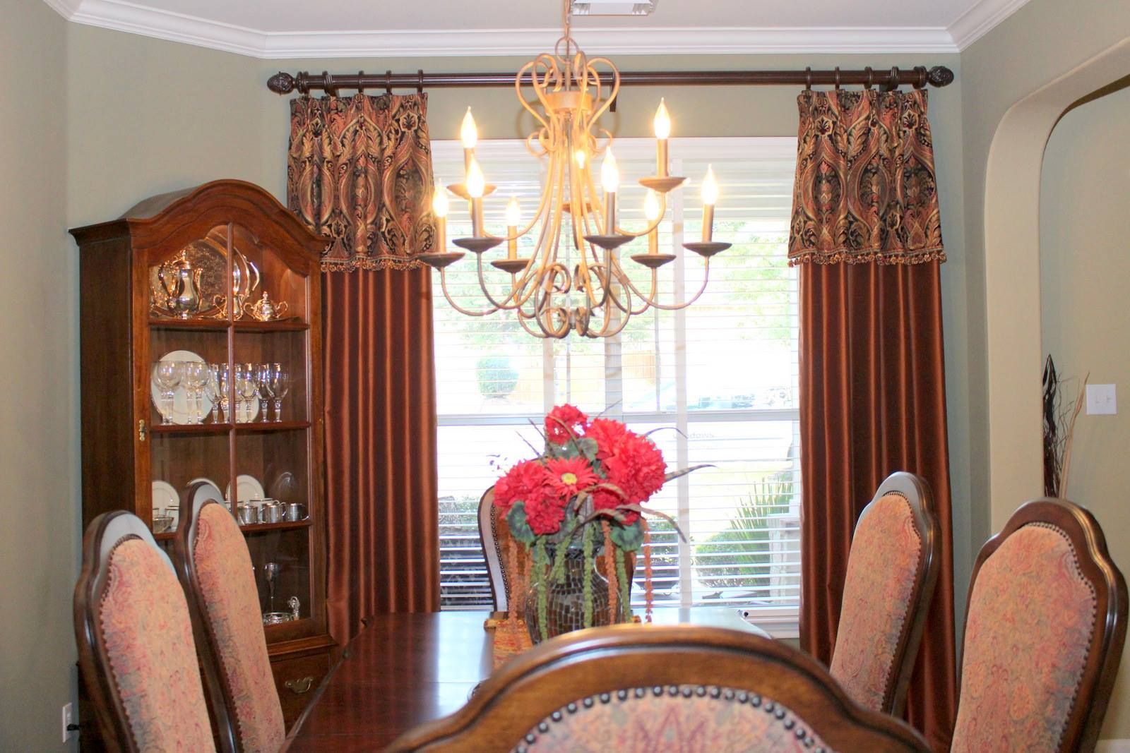A dining room with a table and chairs and a chandelier