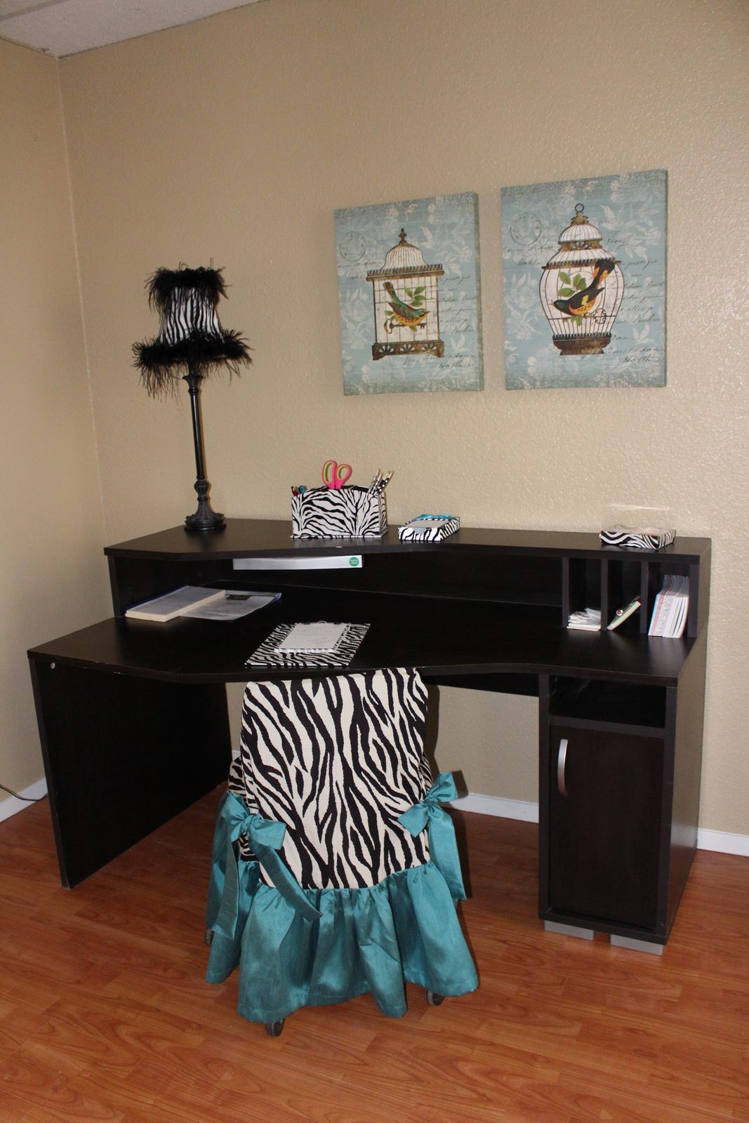A desk with a zebra print chair and a lamp