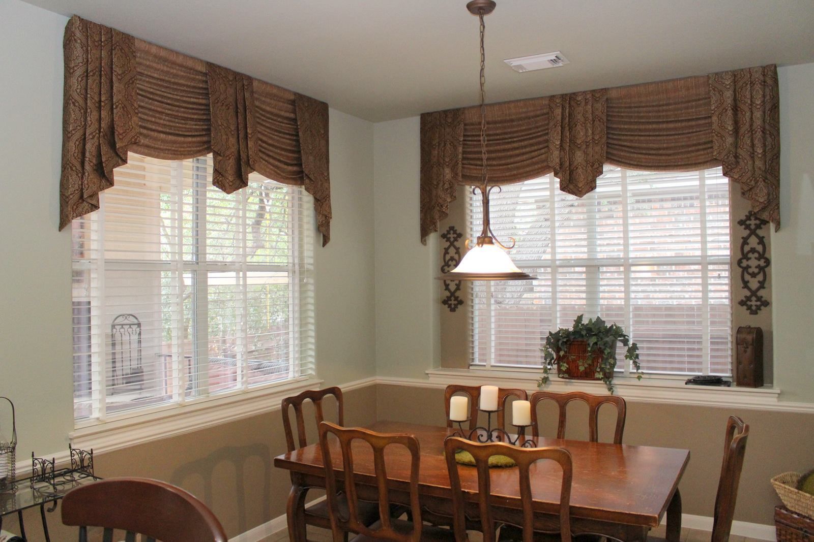 A dining room with a table and chairs and a window with blinds.
