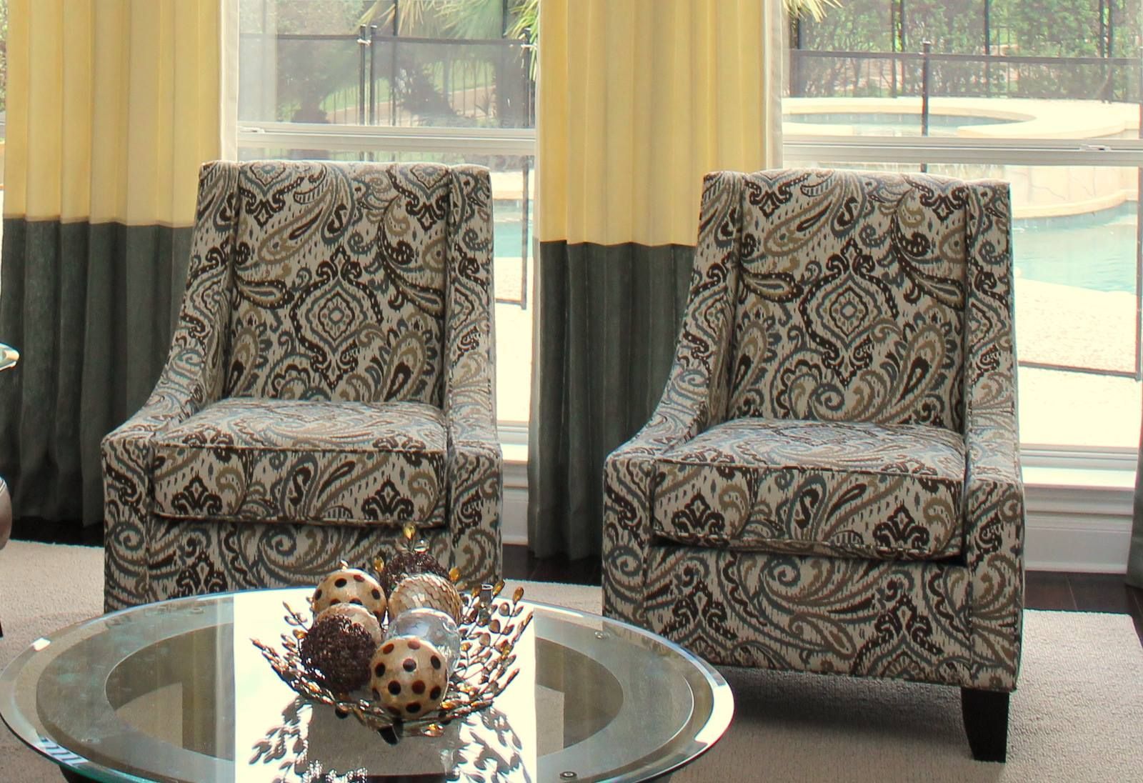 A living room with two chairs and a glass coffee table