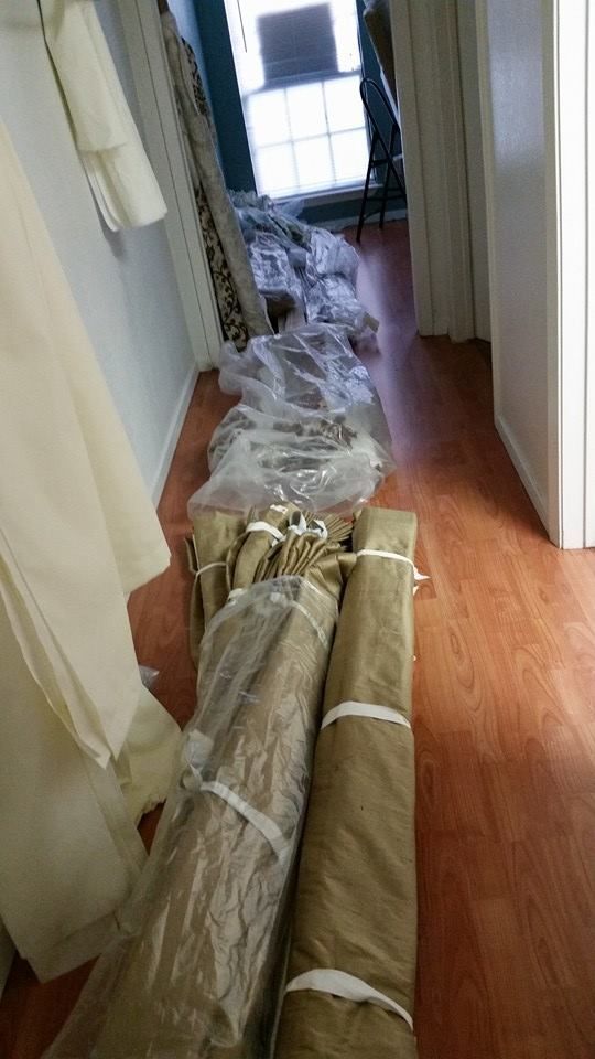 A hallway with a bunch of rolls of fabric wrapped in plastic.