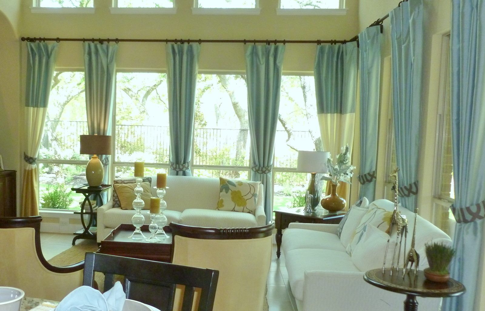 A living room with a white couch and blue curtains