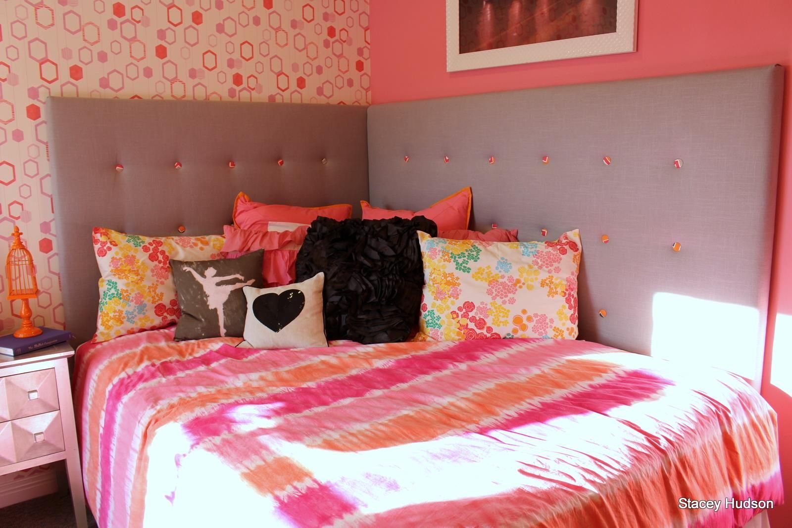 A bed with a pink blanket and pillows in a bedroom