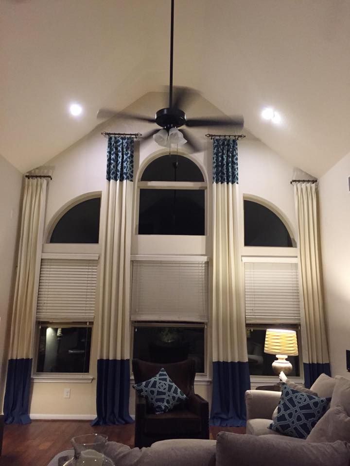 A living room with curtains and a ceiling fan