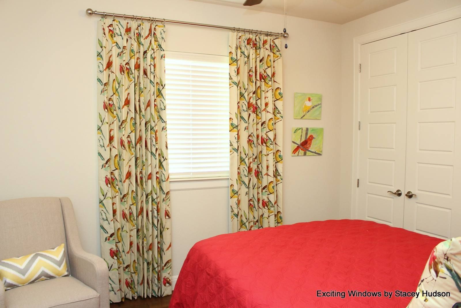 A bedroom with a red bed and a chair