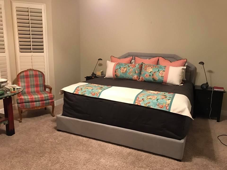 A bedroom with a king size bed and a chair