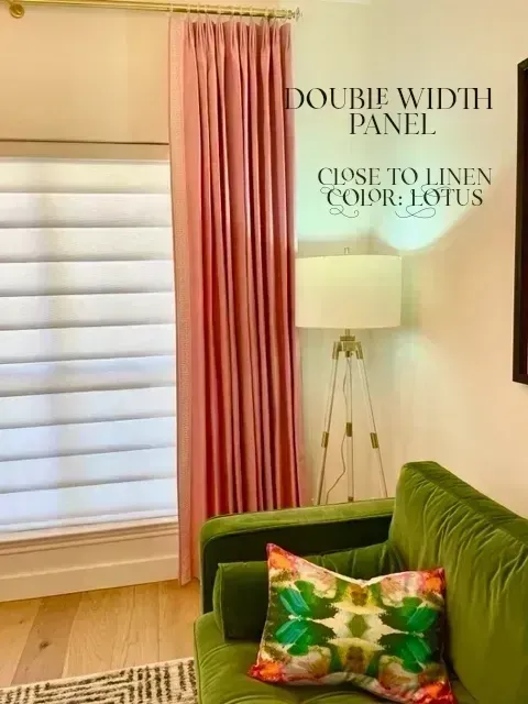 A living room with a green couch and pink curtains